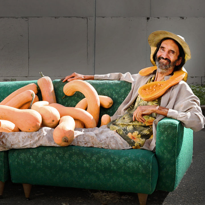 Steve Spangler smiles as he reclines on sofa covered in Tahitian Melon Squash.