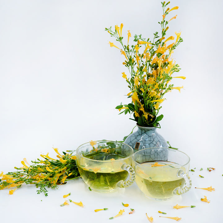 Sunset Yellow Agastache in a small vase with agastache tea on a white background.