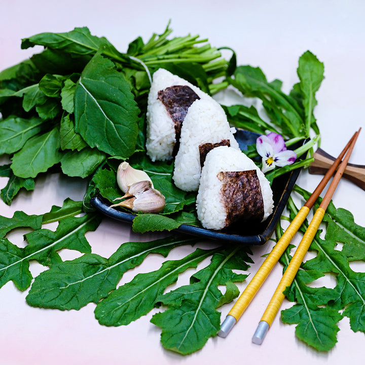 Common Arugula with rice sushi on a plate with leaves.