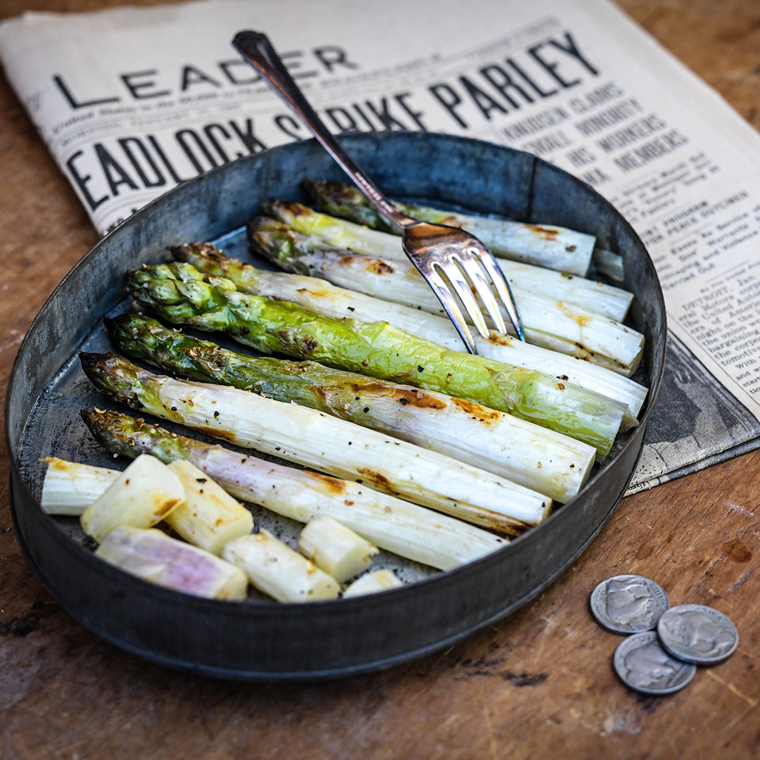 Grilled Conovers Colossal Asparagus in a tin plate with a vintage Springfield Newsleader.