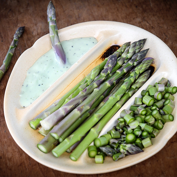 Chopped and whole Mary Washington Asparagus with dip on an asparagus plate.