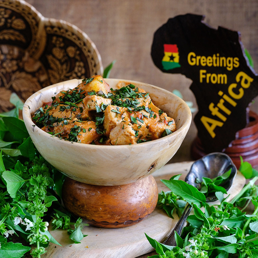 Akoko Mesa Basil tofu recipe in a wooden bowl with fresh basil and props from Ghana.