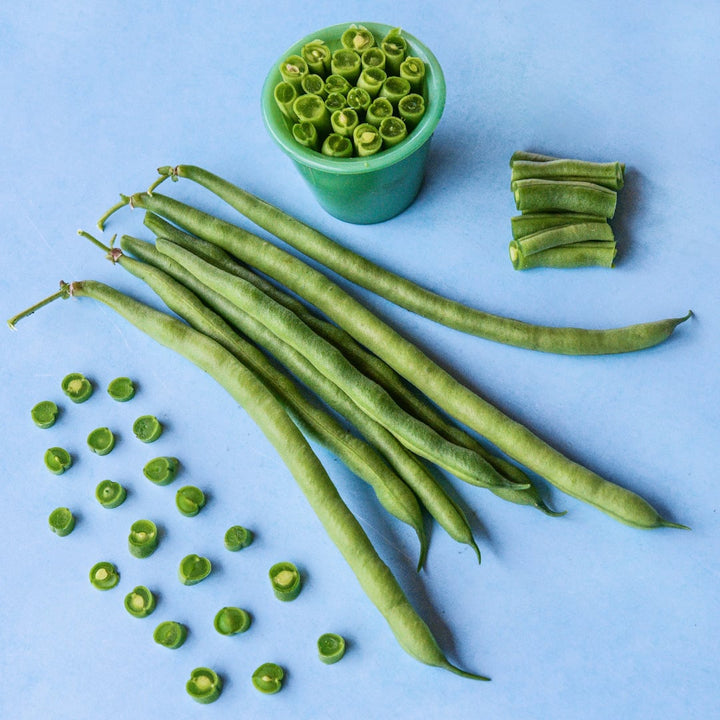 Whole and cut Jade Bush Beans arranged aesthetically on a light blue background.