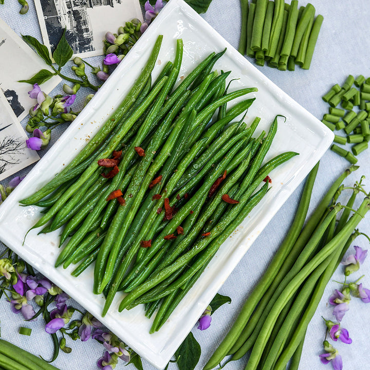 Cooked Nautica Dwarf Beans surrounded by French postcards, purple blooms and fresh beans.