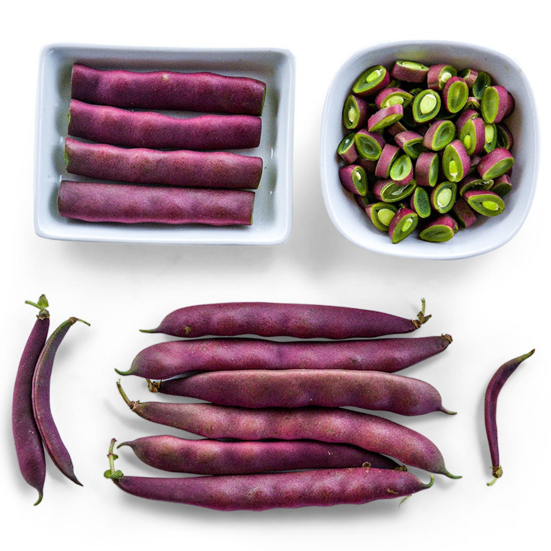 Cut and whole Red Swan Bush Beans arranged on a white background.