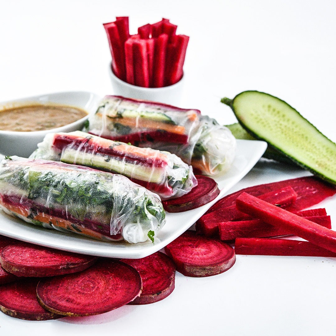 Renova Beets spring rolls with cut beets on a white background.