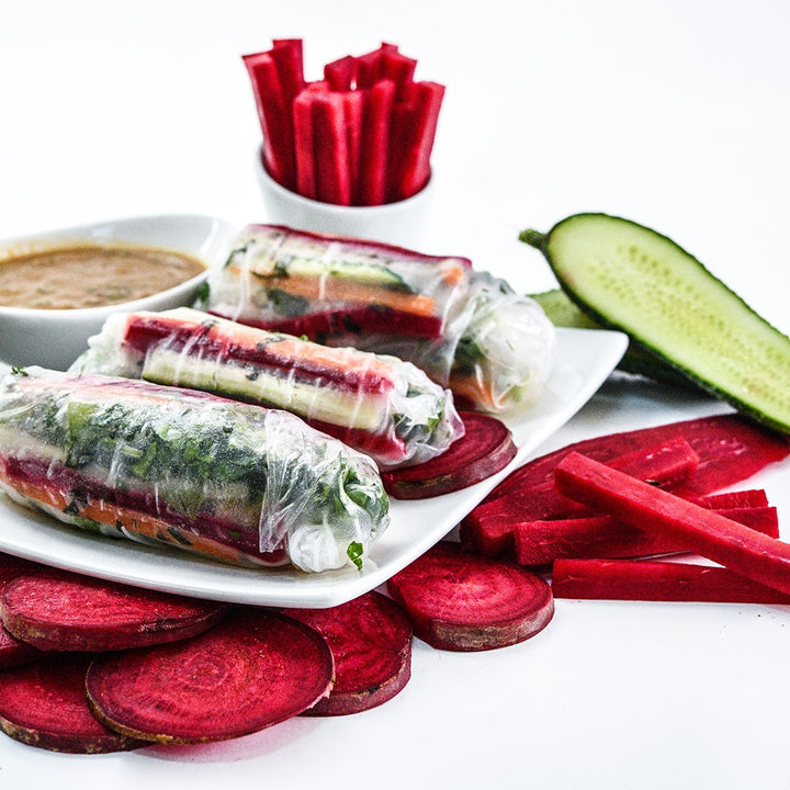 Renova Beets spring rolls with cut beets on a white background.