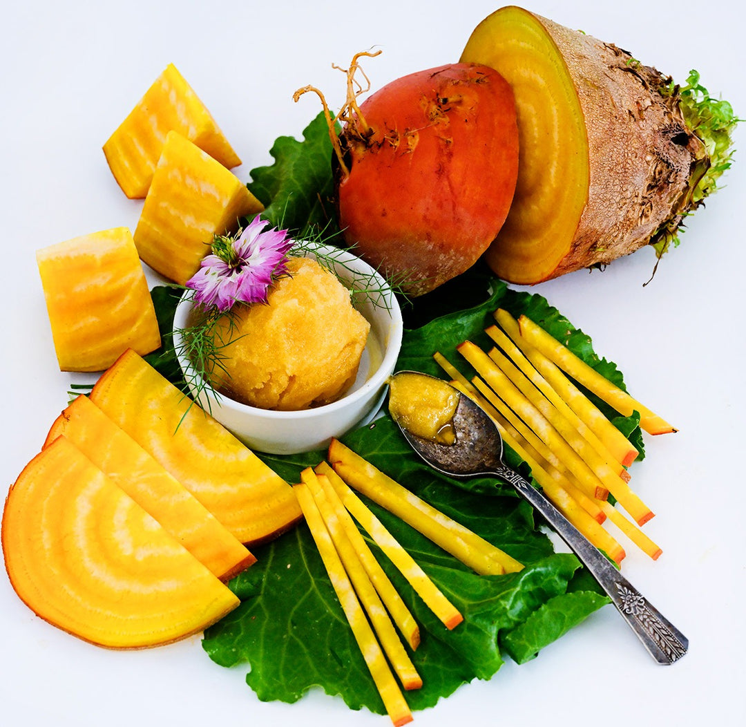 Golden Beet sorbet with sliced and diced beets on a leave resting on a white background.