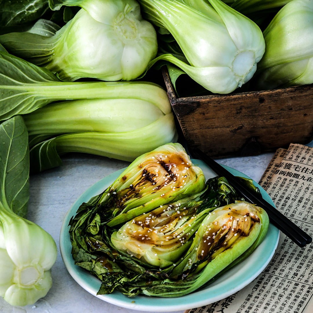 Shanghai Green Bok Choy recipe with fresh bok choy and a Chinese newspaper.