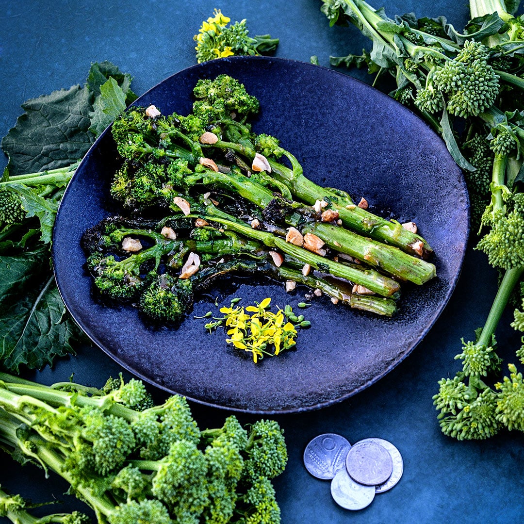 Natalina Di Fasano Cima Grande Broccoli Rabe sauteed on a plate with fresh rabe around the plate.