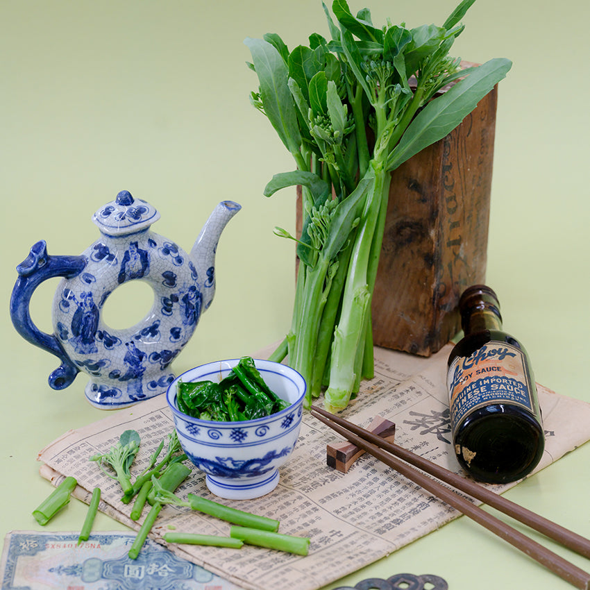 Broccoli Yod Fah with Asian props on a light green background.