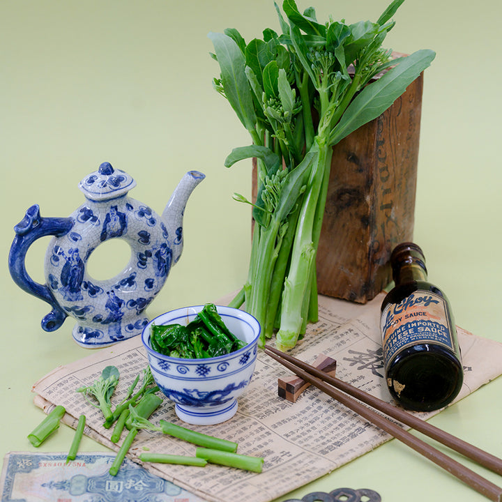 Broccoli Yod Fah with Asian props on a light green background.