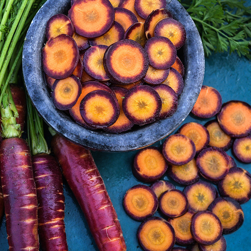 Close-up view of sliced Lila Lu Sang Carrots on a dark blue background.
