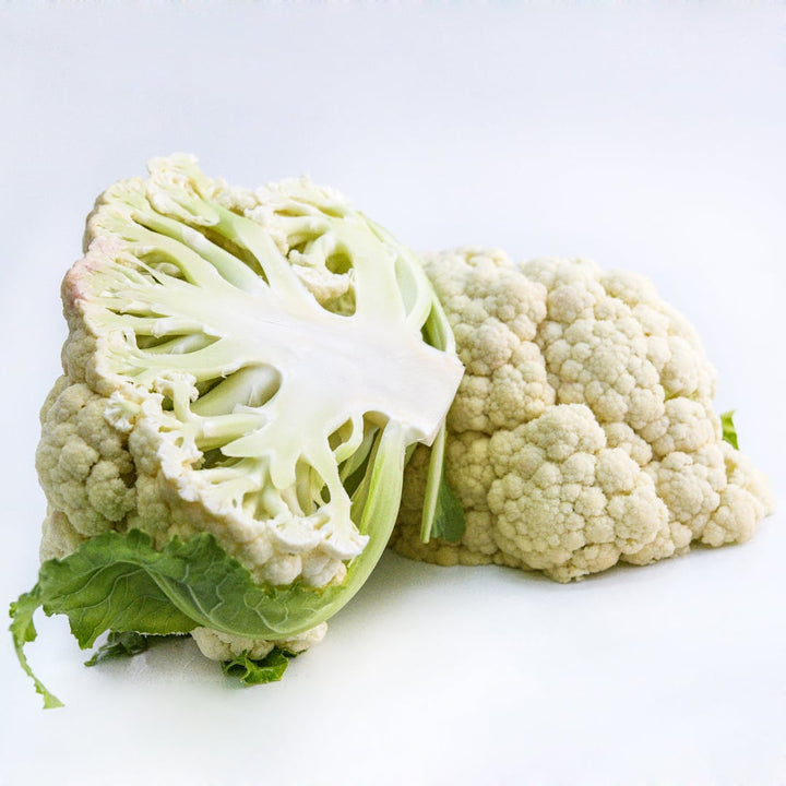 A head of Rober Cauliflower sliced in half on white background.