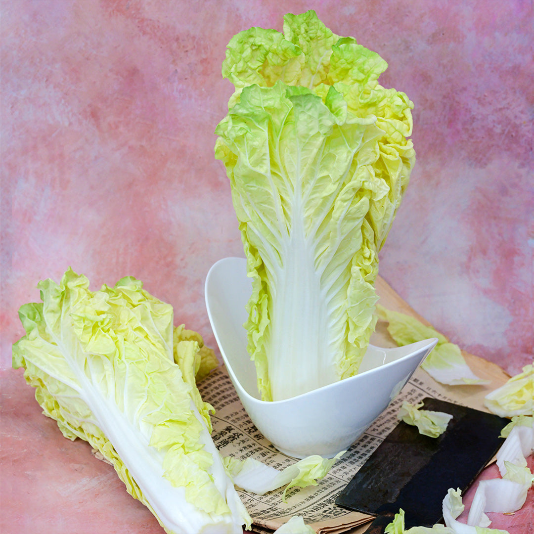 Golden Beauty Chinese Cabbage arranged on pink background with a knife.