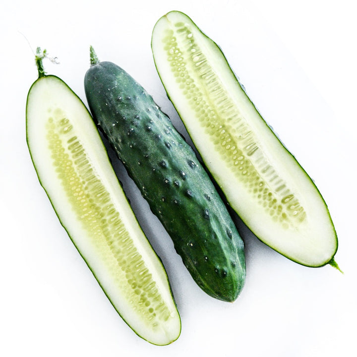 One whole and two halves of Ancash Market Cucumbers on a white background.