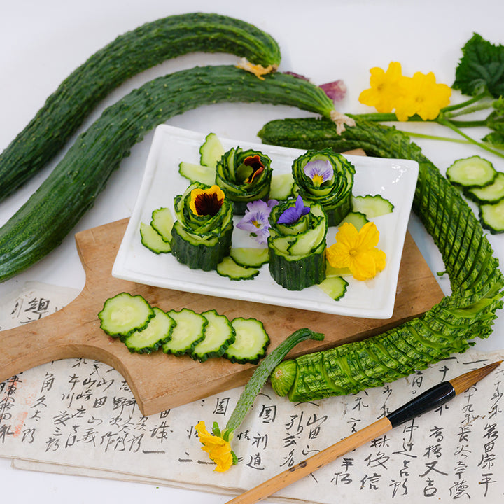 Suyo Long Cucumber sliced and presented on white plate with blooms.
