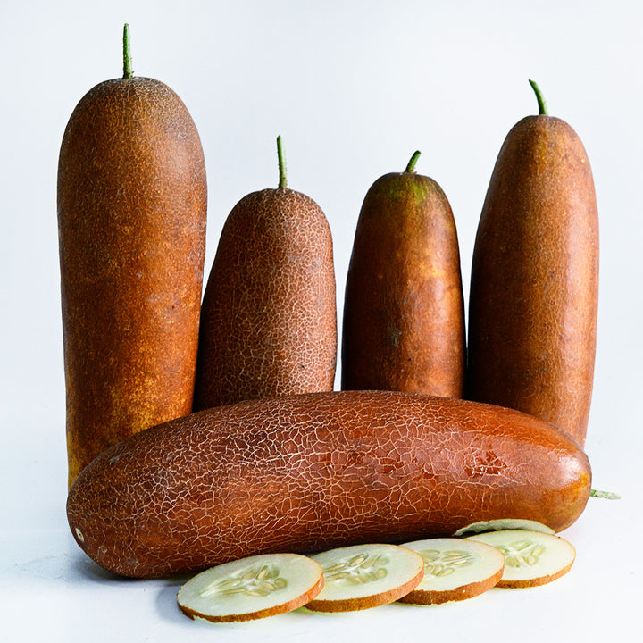 Five Gagon Cucumbers with slices arranged on a white background.