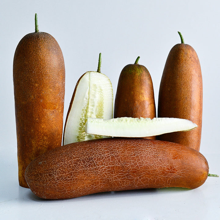 Cut and whole Gagon Cucumbers arranged on a white background.