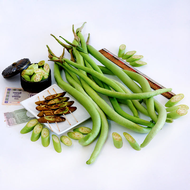 Illikomban Eggplant with slices and grilled eggplant and props from India on a white background.