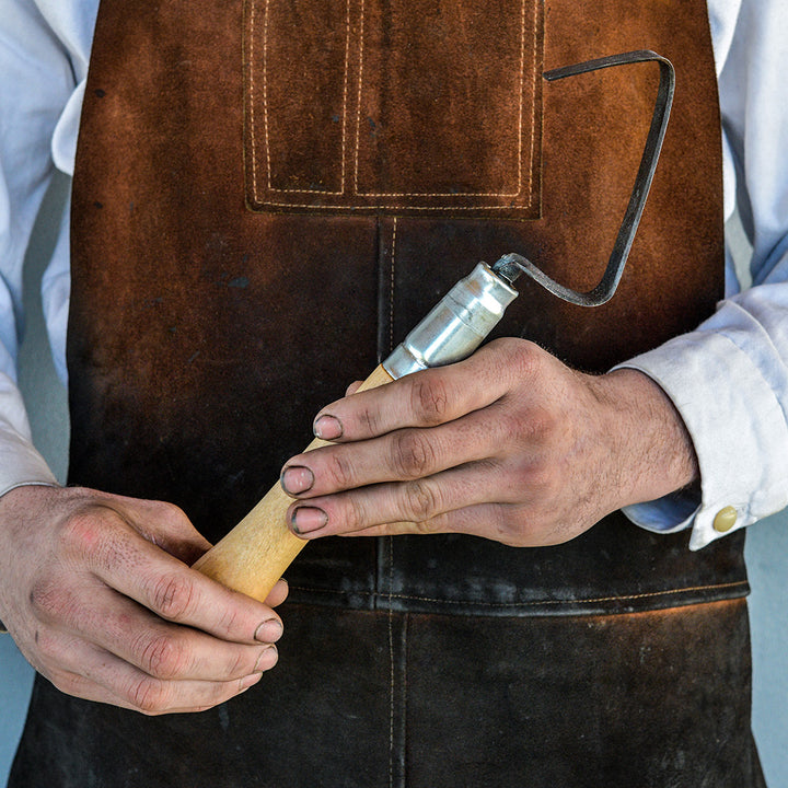 The Baker Creek blacksmith holding a Haseltine Hand Weeder and Scraper that he forged.