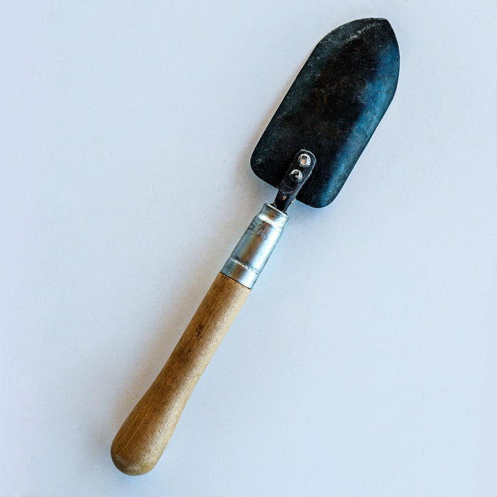 The backside of the Long Handled Trowel on a light background.