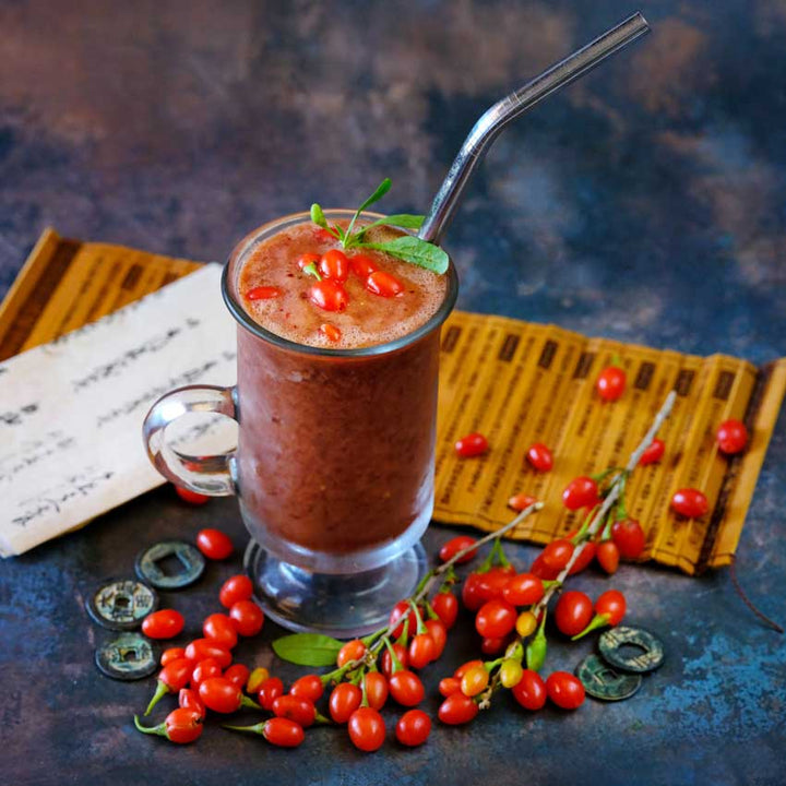Scarlet Goji Berries with a smoothie on a dark blue background.