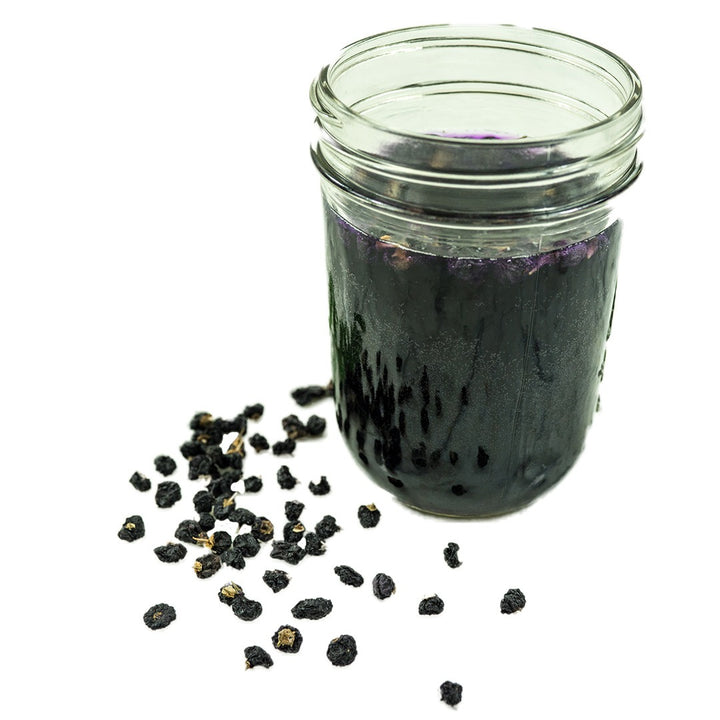 Black Goji Berries with Goji Berry Tea on a white background.