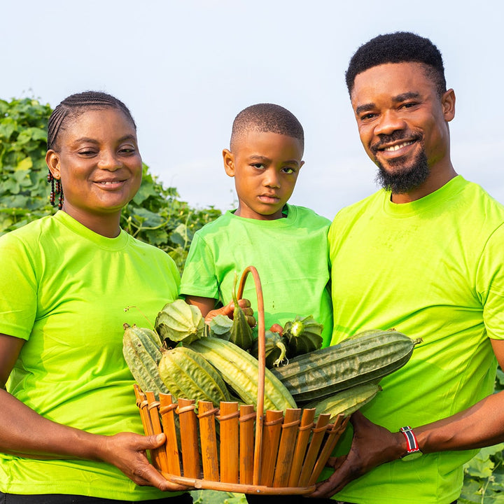 Baker Creek seed grower Solomon Amuzu and his wife and son holding a basketful of Krobonko Luffa Gourds.