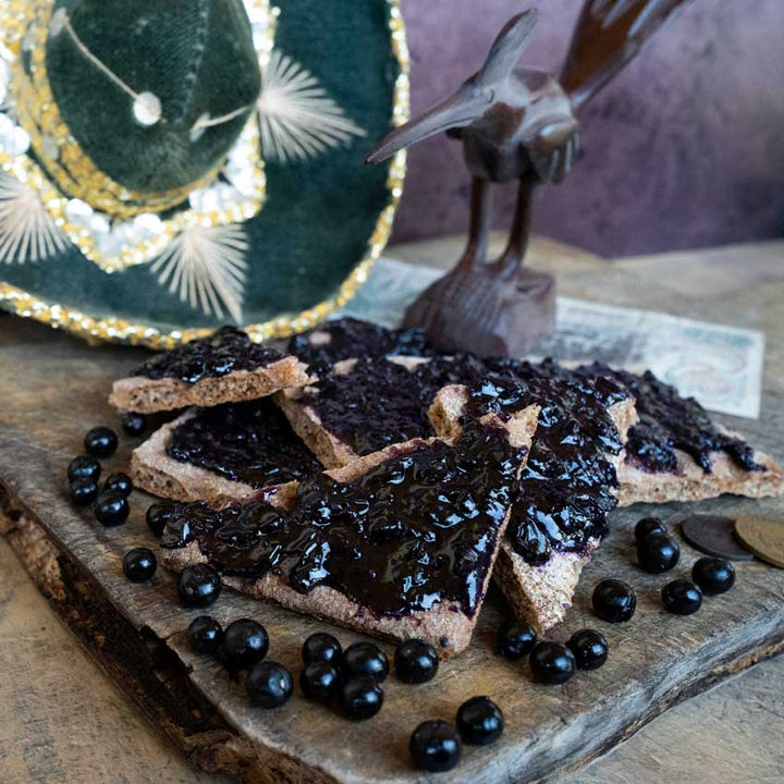 Chichiquelite Huckleberry jam with berries on triangle bread pieces.