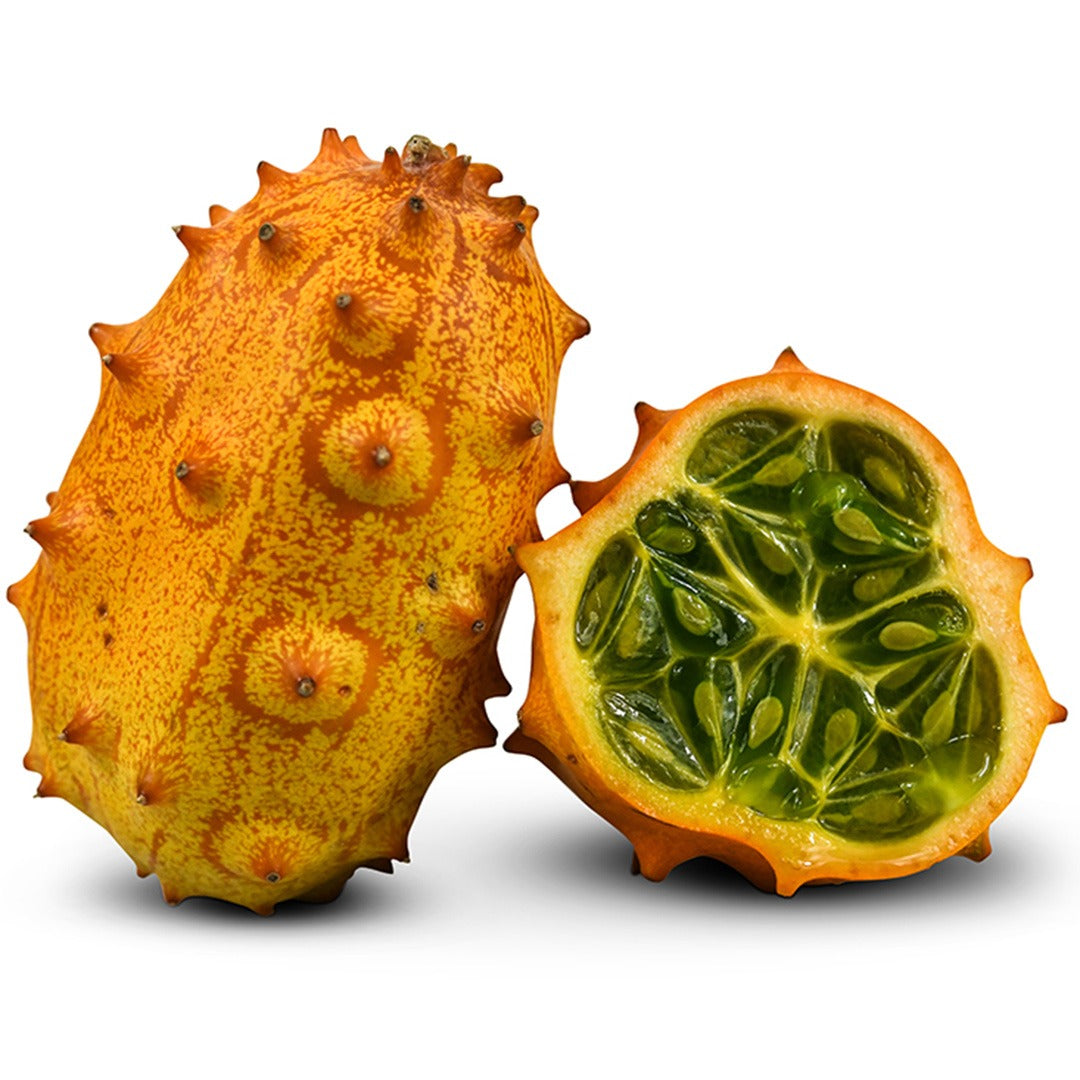 Whole African Horned Kiwano Jelly Melon next to one cut in half to show the seeds on a white background.