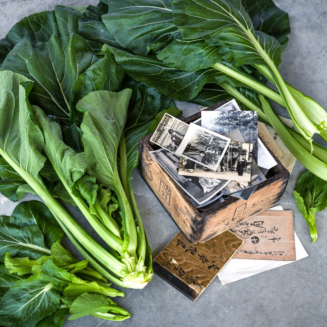A couple of heads of Spinach Mustard "Old Tokyo" Komatsuna with a wooden box of pictures.