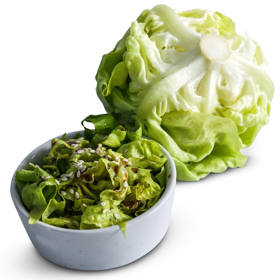 May Queen lettuce next to a bowl of cut lettuce on a white background.