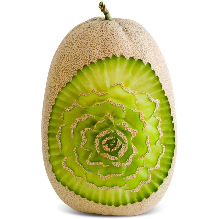 Bateekh Samarra Melon with intricate flower carving on a white background.