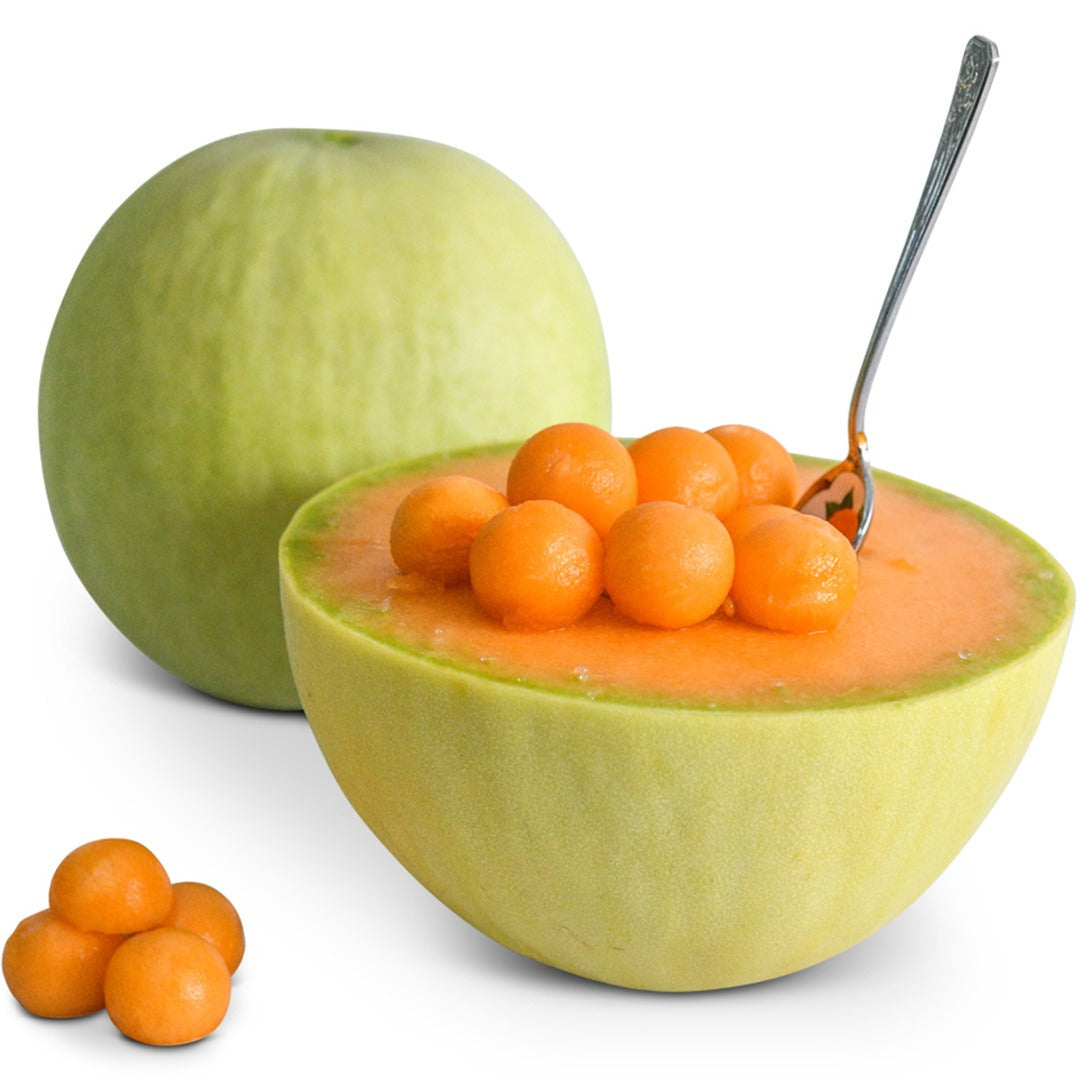 Whole and cut Honeydew Orange Flesh Melon with melon balls on a white background.