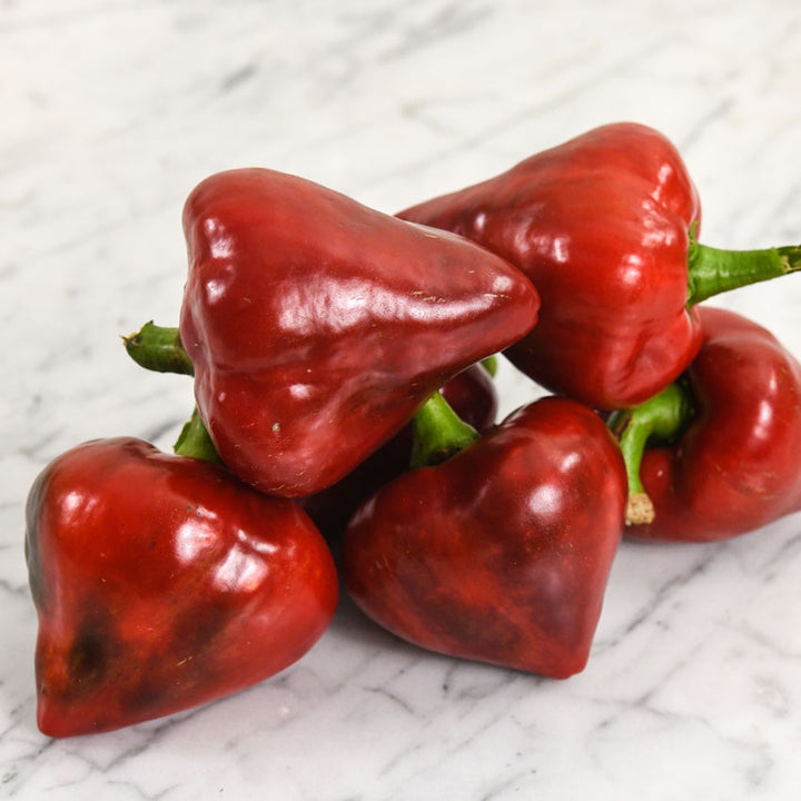 A pile of Lesya Sweet Peppers on a marble background.