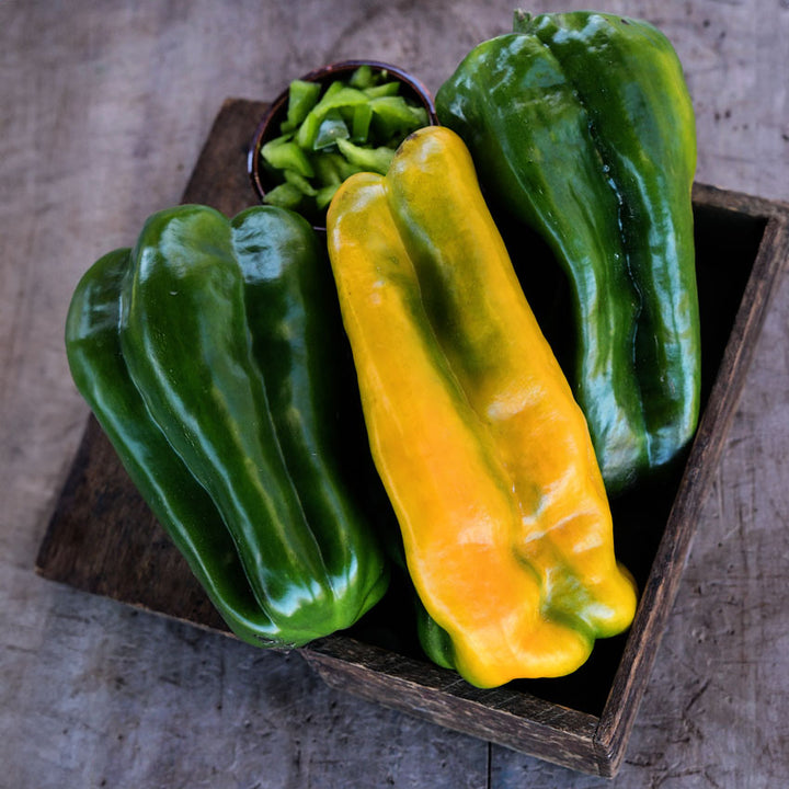 Wooden box of Yellow Monster Peppers in shades of green to greenish-yellow