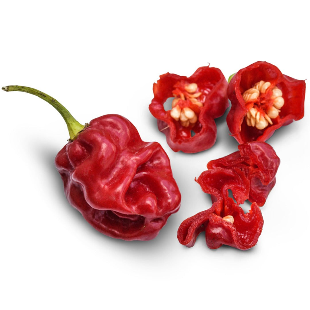 Whole and sliced Asante Hot Peppers on a white background.