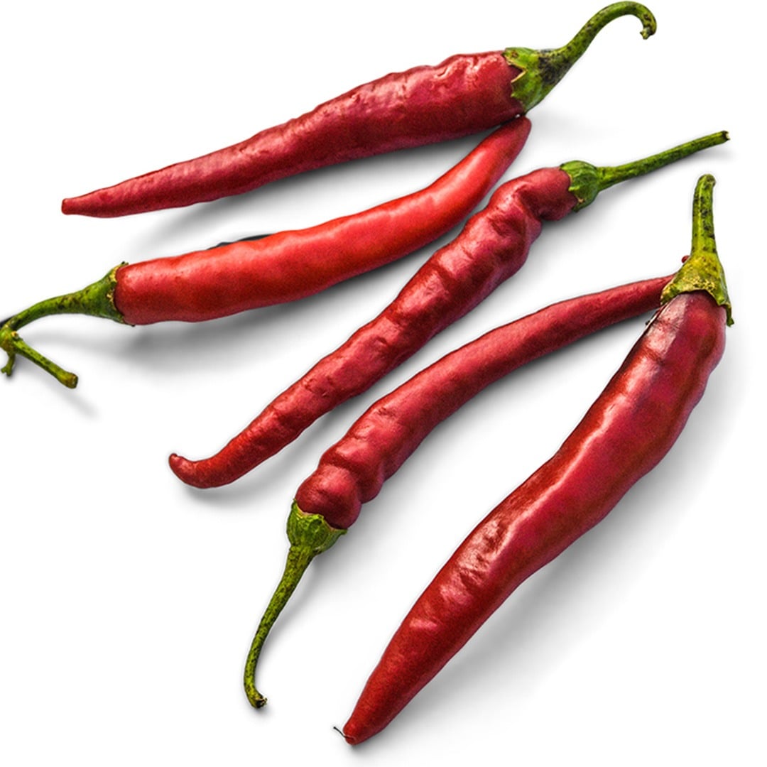 Five Cayenne Long Thin Peppers on a white background.