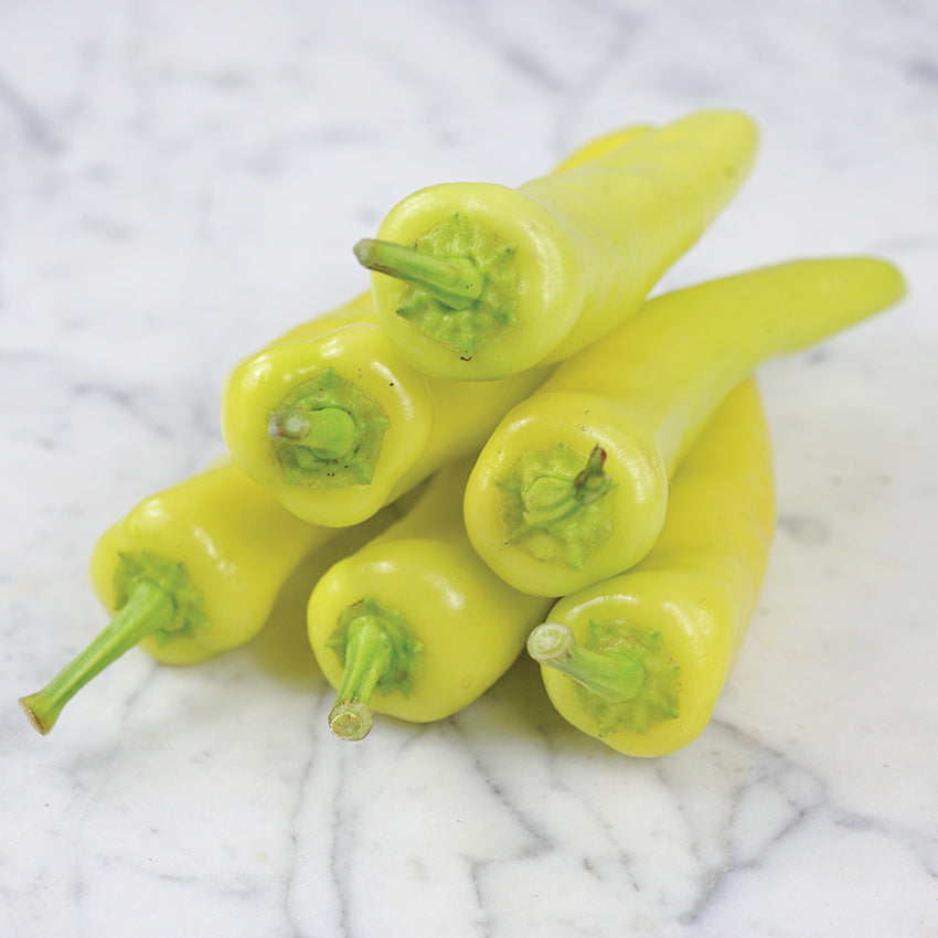 Hungarian Hot Wax Peppers stack on marble countertop