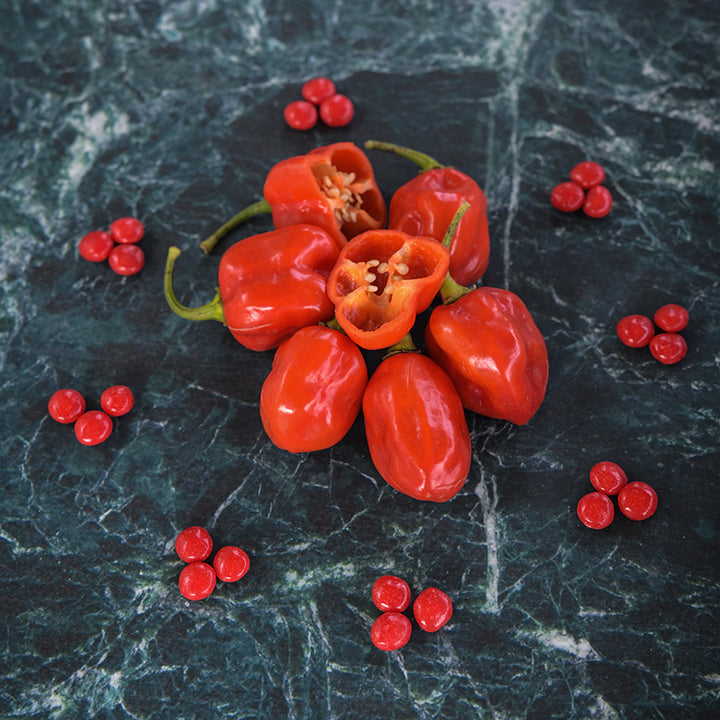 Red Savina Peppers on grey and white marbled countertop.