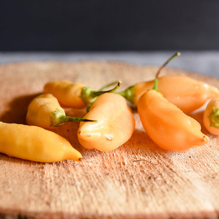 Sugar Rush Peach Peppers on wooden plank.