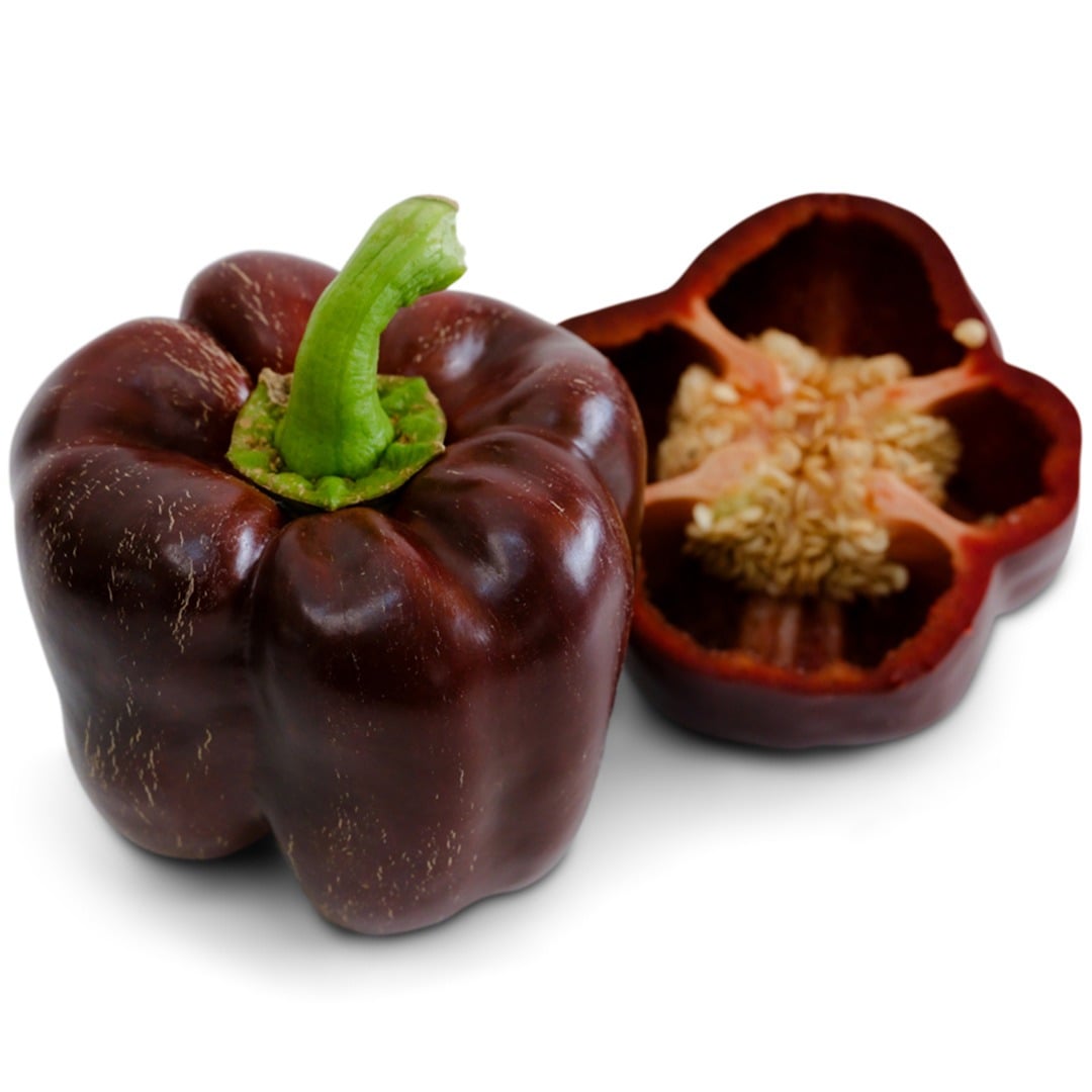 Whole and cut Chocolate Beauty Sweet Peppers on a white background.