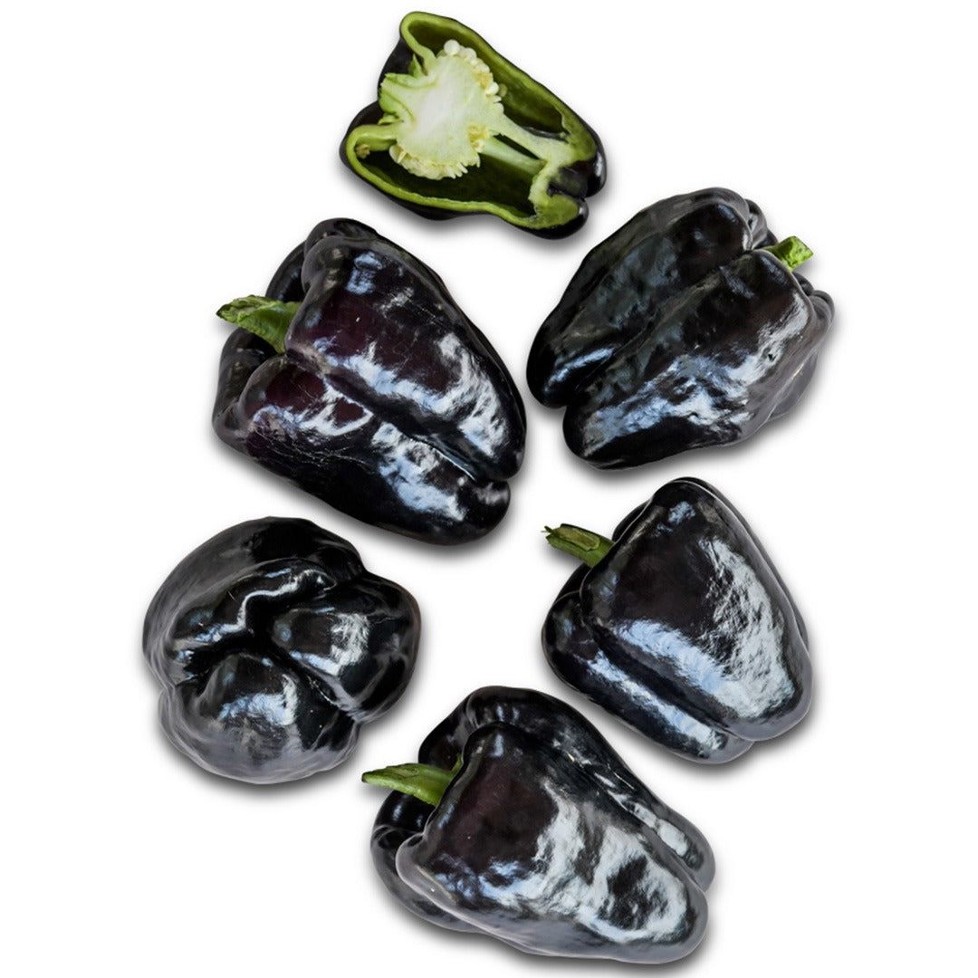 Several whole and one cut Zulu Sweet Peppers on a white background.