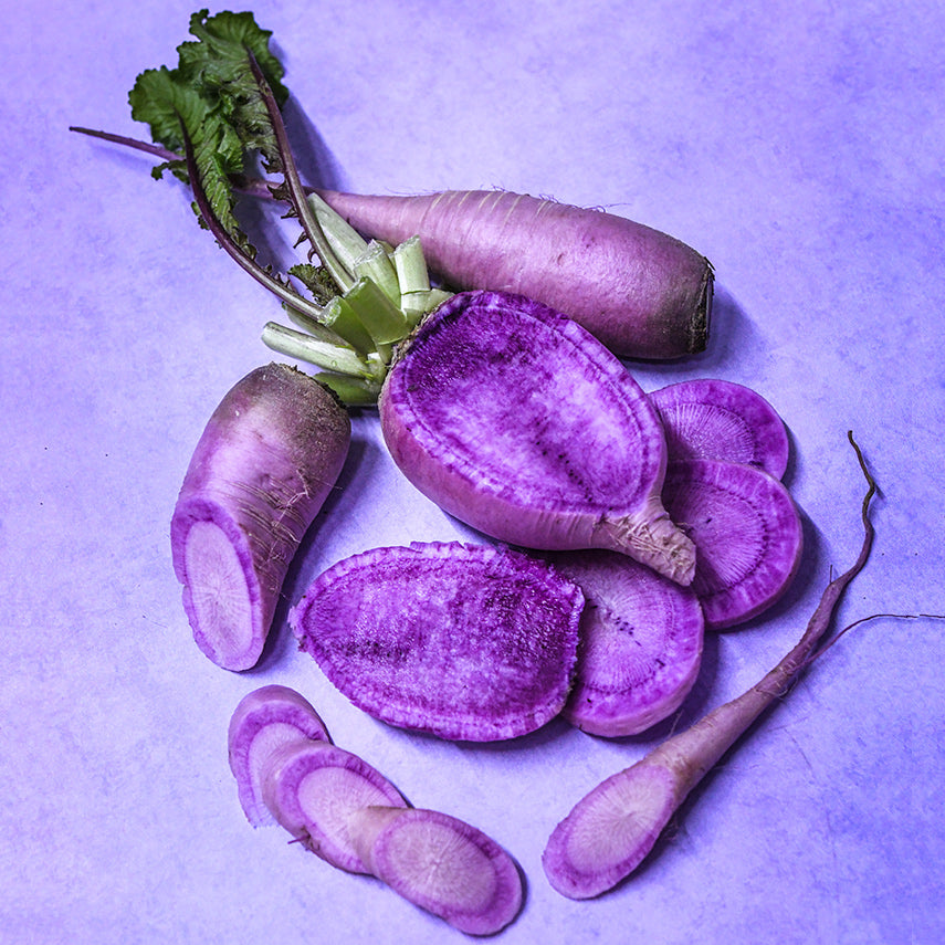 Cut Pusa Jamuni Radishes on a purple background.