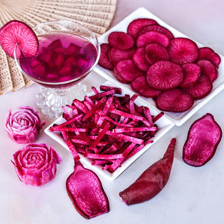 Sliced and juiced Red Beauty Radishes with radish roses and a fan on a light background.