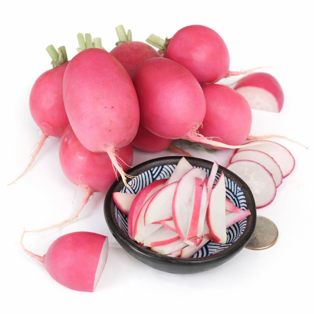 Several Pink Dawn radishes with slices arranged on a white background.