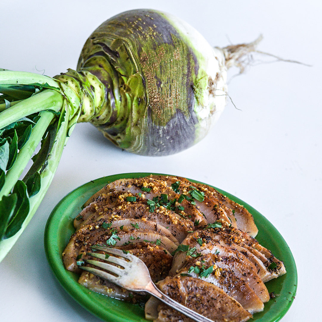 A Macomber Turnip Rutabaga with roasted and seasoned rutabaga on a white background.