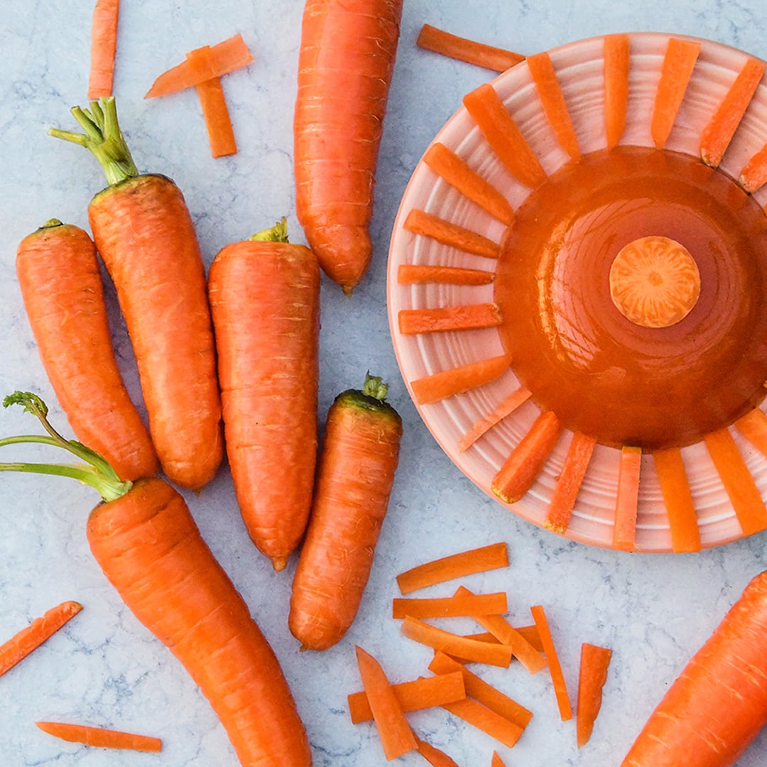 New Kuroda Carrots with a plate of carrot jello on a light background.