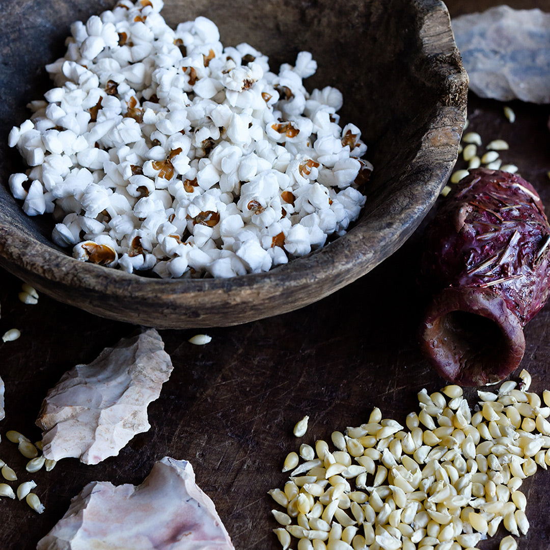 Popped Burro Mountain Popcorn in a wooden bowl with un-popped kernels.